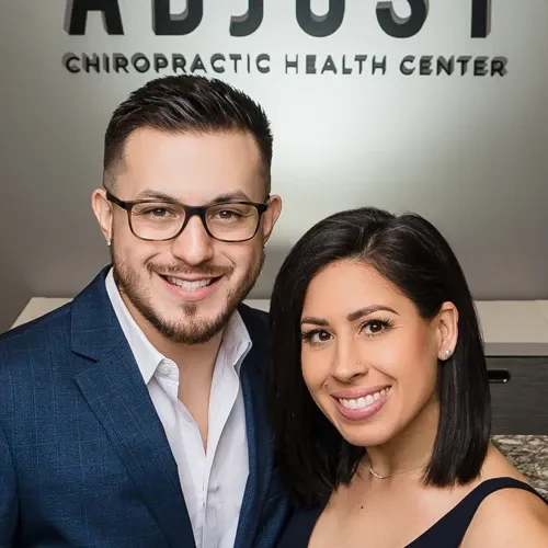 Drs. Jason Abaza and Marissa Abaza posing for a photo in the front of their clinic