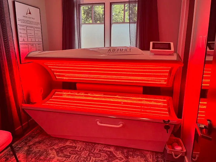Interior of an open red light therapy pod with bright infrared bulbs visible