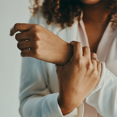 A woman holding her wrist with arthritis and carpal tunnel pain