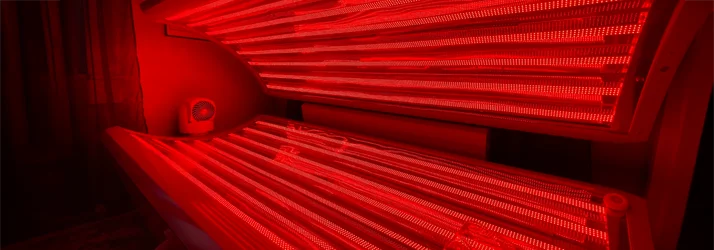 Red light therapy bed with lid open, showing illuminated infrared panels