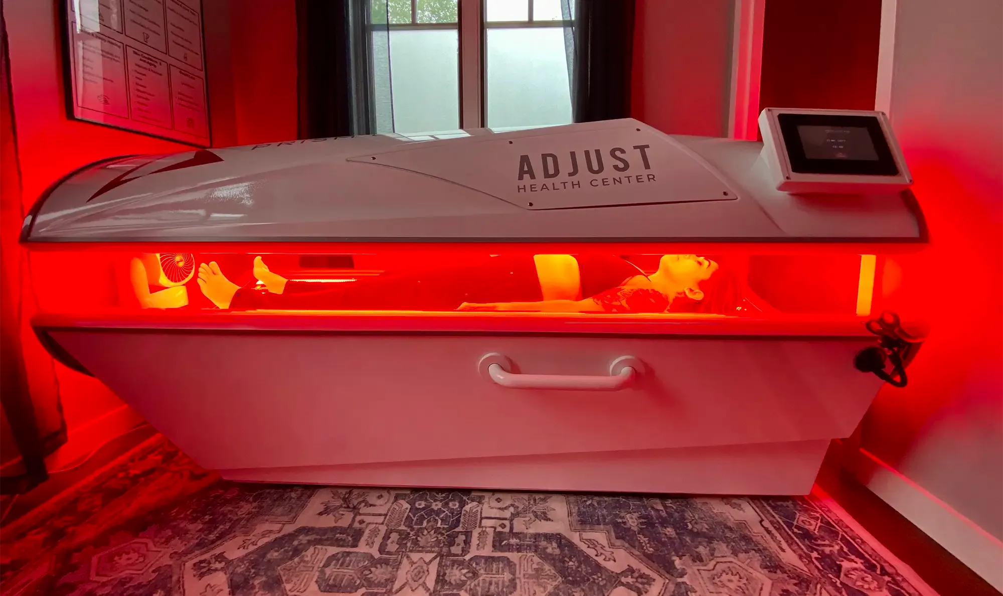 A patient lying inside a red light therapy pod during treatment