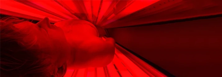 Person Relaxing In Red Light Therapy Bed